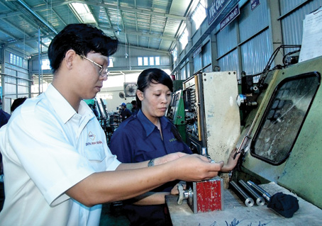 Giám đốc Nguyễn Văn Nghĩa hướng dẫn công nhân tại xưởng sản xuất.