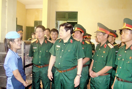 General Phung Quang Thanh visits the kitchen of Nguyen Hue University.