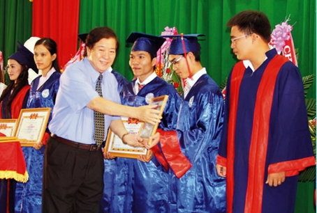 Tiến sĩ Đỗ Hữu Tài đang trao bằng khen cho sinh viên Trường đại học Lạc Hồng.