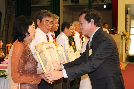 Vice Chairman Nguyen Thanh Tri awards certificates of merit to 7 individuals for their contributions to the hospital's development.