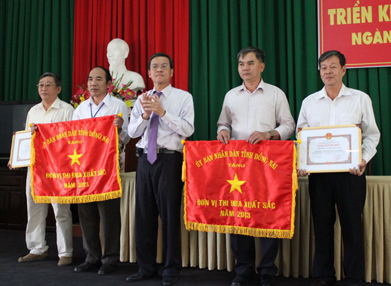 Vice Chairman Tran Minh Phuc of the provincial People’s Committee awards Excellent Emulation Flag to Doloco