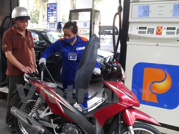 Nhân viên cửa hàng xăng dầu của Petrolimex đang bán xăng cho khách hàng (Ảnh: Vietnam+)