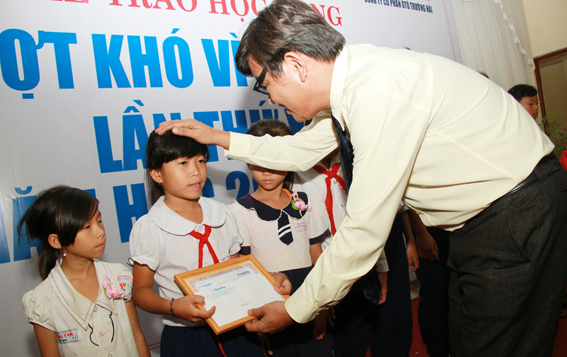Nhà văn Nguyễn Một, Giám đốc truyền thông, Công ty cổ phần ô tô Trường Hải trao giấy khen và quà cho các em học sinh