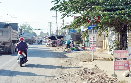 Biển báo “núp” lùm cây trên quốc lộ 51, đoạn rẽ vào đường Đinh Quang Ân (xã Phước Tân, TP.Biên Hòa).