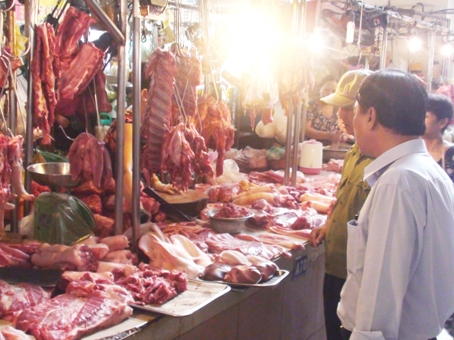 Ban quản lý chợ Biên Hòa kiểm tra chất lượng thịt heo được bày bán tại sạp. Ảnh: D.Linh
