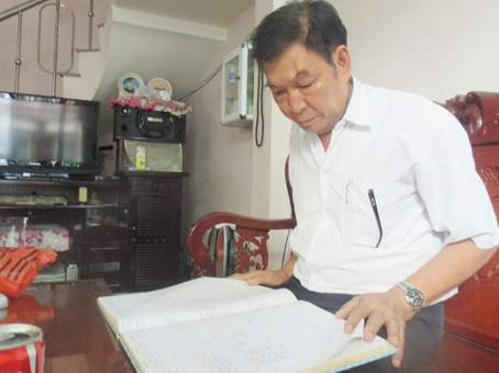 Ông Nguyễn Xuân Oanh với “bửu bối” là danh sách 800 hộ gia đình trong khu phố được cập nhật liên tục.