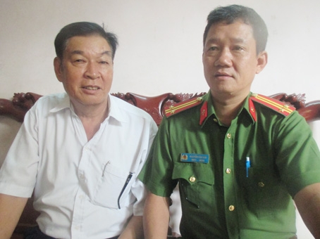  Ông Nguyễn Xuân Oanh trao đổi tình hình an ninh trật tự khu phố với cảnh sát khu vực.