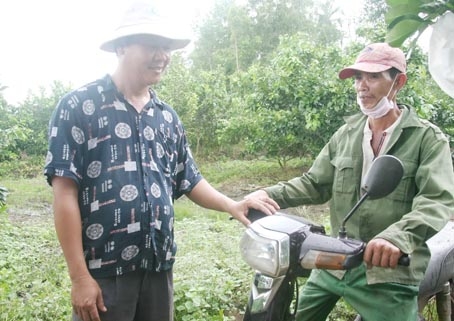 Ông Nguyễn Văn Quán, ngụ xã Bảo Bình, huyện Cẩm Mỹ  (bên trái) giao xe máy cho người lao động để họ làm phương tiện đi lại.