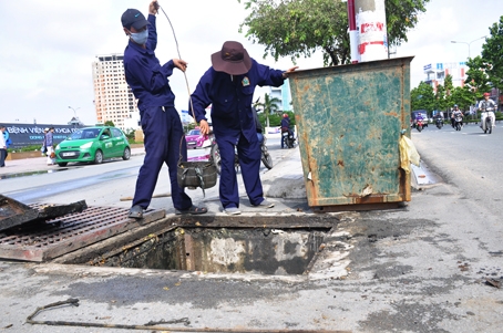 Các công nhân nạo vét bùn cát tại cống thoát nước trước khu vực Bệnh viện đa khoa Đồng Nai (phường Tam Hòa). Ảnh: Văn Chính