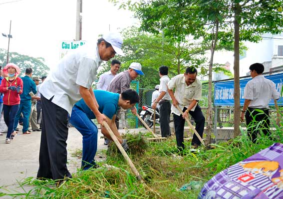 Bí thư Thành ủy Biên Hòa Lê Văn Dành (bìa trái) tham gia dọn dẹp vệ sinh trên tuyến đường vào khu vực chợ Tam Hòa.  Ảnh: V.Chính