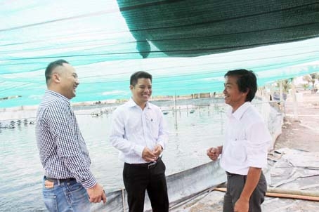 Ông Banchong Buahung (bìa trái), Giám đốc kỹ thuật bộ phận thủy sản của Công ty cổ phần chăn nuôi C.P. Việt Nam, trao đổi với người nuôi tôm tại huyện Nhơn Trạch về kỹ thuật nuôi tôm theo công nghệ mới.