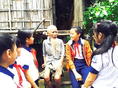 Học sinh, sinh viên cần được định hướng giáo dục truyền thống yêu nước. Trong ảnh: Học sinh Trường THCS Mã Đà (huyện Vĩnh Cửu) thăm hỏi già làng Năm Nổi (người dân tộc Chơro, xã Phú Lý).
