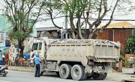 Một xe tải ben chở vật liệu xây dựng phủ bạt, nhìn bên ngoài không thấy chở vun ngọn, nhưng khi lực lượng chức năng kiểm tra thì phát hiện chở quá mép thùng xe từ 20-30cm. Ảnh: T.HẢI