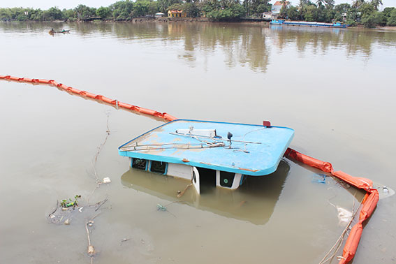 Cảnh sát môi trường đã dùng phao để chắn ngăn dầu tràn ra sông.