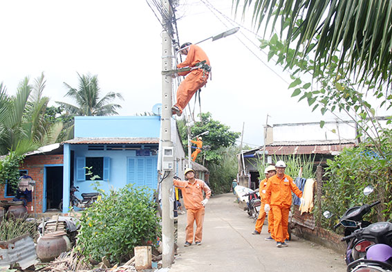 Công nhân Điện lực Nhơn Trạch đang thi công hệ thống chiếu  sáng tại ấp Phước Lương, xã Phú Hữu, huyện Nhơn Trạch.