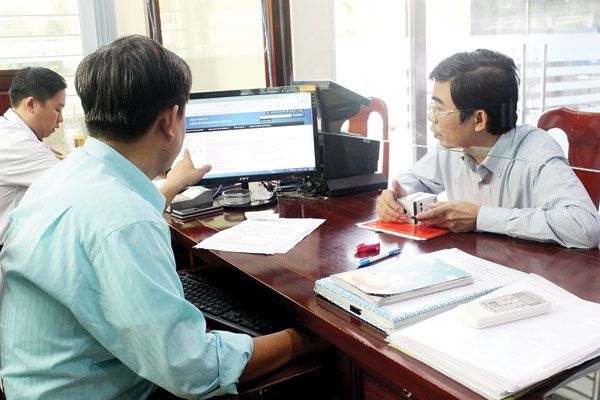 Công chức Sở Kế hoạch - đầu tư hướng dẫn người dân làm hồ sơ đăng ký doanh nghiệp qua mạng. Ảnh: Đặng Ngọc