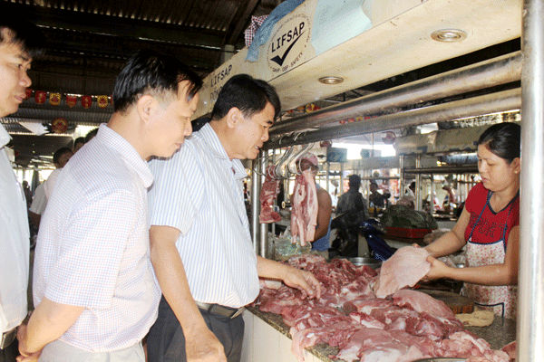 Ông Phan Minh Báu, Phó giám đốc Sở Nông nghiệp – phát triển nông thôn kiểm tra gian hàng thịt an toàn tại chợ Vĩnh An. Ảnh: B.Nguyên