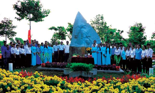 Đồng chí Huỳnh Văn Tới  và cán bộ, công nhân viên Văn miếu Trấn Biên bên tượng Thi tướng Huỳnh Văn Nghệ tại công viên vườn tượng Danh nhân.