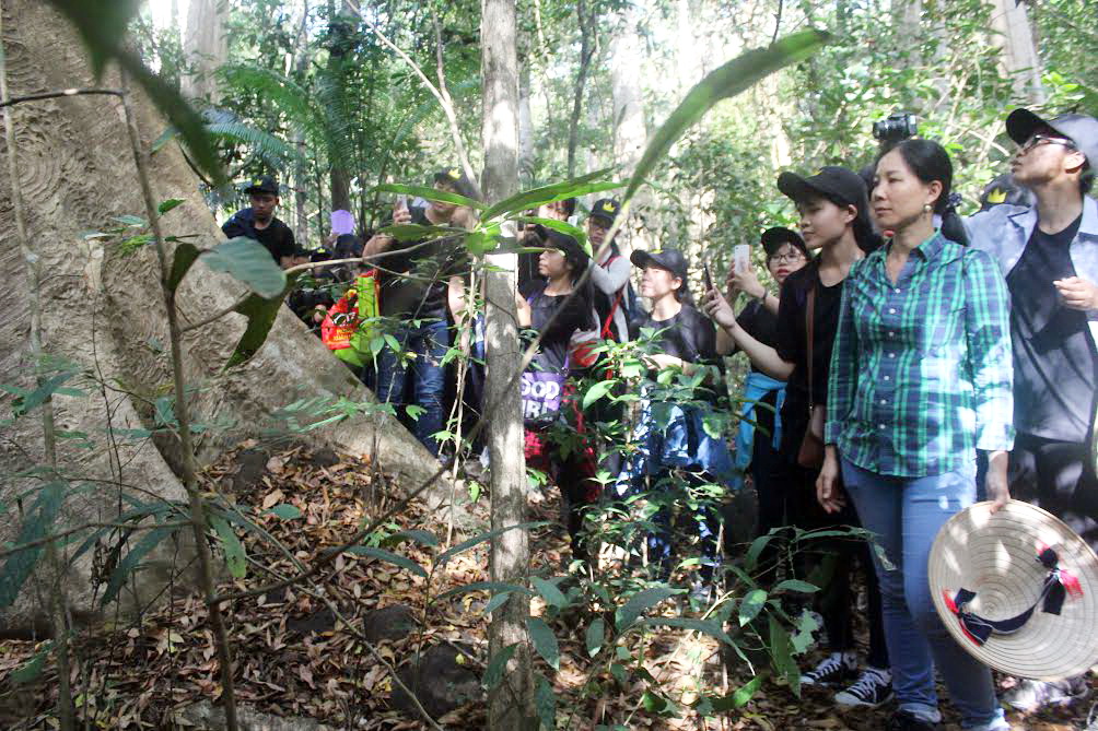 Các em học sinh đi thực tế và nghe hướng dẫn viên giới thiệu về thảm thực vật tại Vườn quốc gia Cát Tiên