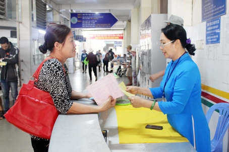 Bà Nguyễn Thị Anh Thư, nhân viên Phòng Công tác xã hội Bệnh viện đa khoa Thống Nhất (phải) hướng dẫn bệnh nhân làm các thủ tục khám, chữa bệnh.