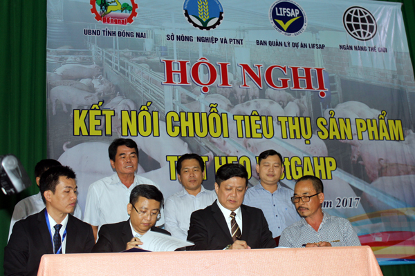Đại diện của MM Mega Market Việt Nam ký kết bao tiêu heo VietGAHP của nông dân Đồng Nai. Ảnh: B.Nguyên
