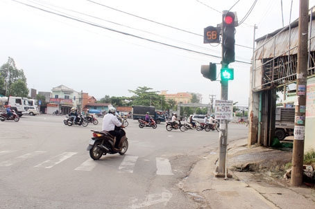 Trụ đèn tín hiệu giao thông tại ngã ba Hồ Văn Đại - Nguyễn Ái Quốc bị chiếm dụng để treo biển quảng cáo. (Ảnh chụp ngày 29-5-2017).
