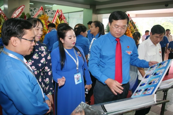 Anh Lê Quốc Phong, Ủy viên dự khuyết Trung ương Đảng, Bí thư thứ nhất Trung ương Đoàn (hàng đầu, ngoài cùng bên phải) xem các cuốn sách ảnh được trưng bày tại đại hội. 