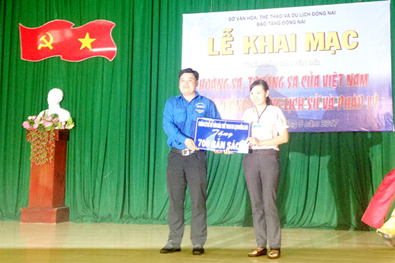 Đoàn cơ sở Sở Văn hóa – thể thao và du lịch trao tặng bảng biểu trưng 700 đầu sách cho chính quyền xã Phú Lý. (ảnh: Thư viện Đồng Nai).