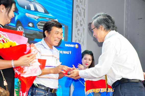 Ông Nguyễn Thành Quang, Phó tổng giám đốc Bảo  trao chìa khóa xe ô tô cho gia đình bà Lê Thị Như Ý. 