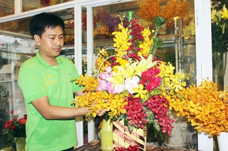 Ông Nguyễn Huỳnh Thái Bảo đang hoàn thành giỏ hoa để giao cho khách. Ảnh: K. Minh