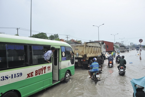 Nước ngập sâu, xe cộ ùn tắc. Trong ảnh: Nhân viên xe buýt “sốt ruột” vì gặp sự cố.