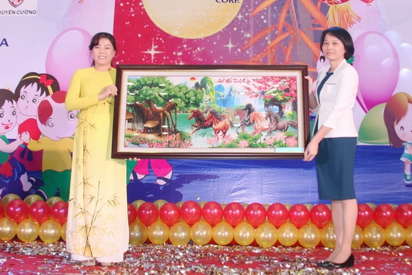 bà Lê Thị Nam Ngạn, Giám đốc Trung tâm Nuôi dạy trẻ khuyết tật Đồng Nai (bên trái) trao tặng quà tri ân cho lãnh đạo Tổng công ty Tín Nghĩa.