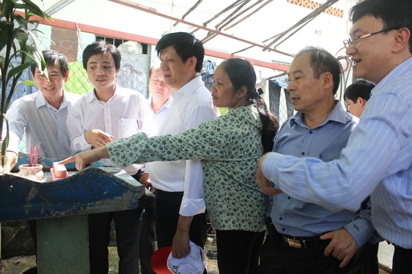 Thứ trưởng Bộ Y tế Nguyễn Thanh Long (giữa) giám sát mật độ lăng quăng tại một hộ dân ở phường Long Bình, TP.Biên Hòa. Ảnh: Ngọc Thư.