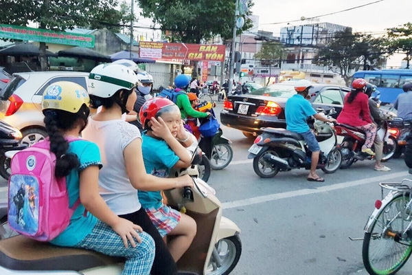 Trẻ được mẹ chở đi tới ngã tư Võ Thị Sáu và Hà Huy Giáp (phường Quyết Thắng, TP.Biên Hòa) phải bịt tai vì tiếng còi xe quá ồn. Ảnh: K.LIỄU