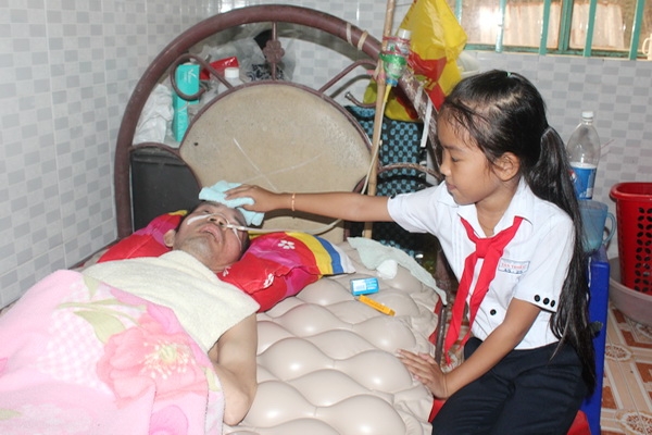 Em Lê Thị Ngọc Thoa, học sinh lớp 4/5 Trường tiểu học Tân Triều (huyện Vĩnh Cửu), chăm sóc cha mỗi khi về thăm.