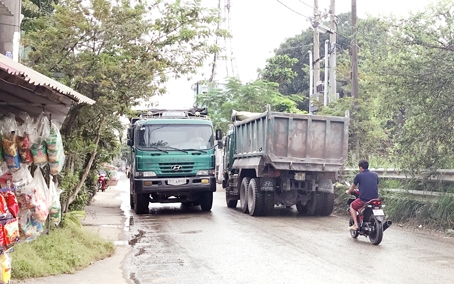 2 xe tải ben đang tranh nhau chạy trên đường Nguyễn Văn Lung gây nguy hiểm cho người dân. Ảnh: P.LIỄU