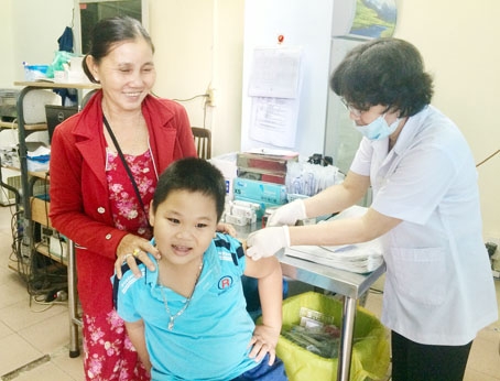 Một phụ huynh đưa con đi tiêm phòng vaccine phòng dại tại Trung tâm y tế dự phòng tỉnh.