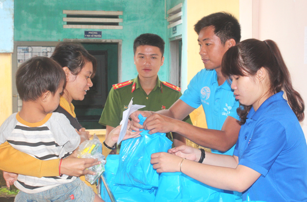 Cán bộ, đoàn viên thanh niên tặng quà cho người dân khi đến khám bệnh, phát thuốc(Ảnh: Nga Sơn)