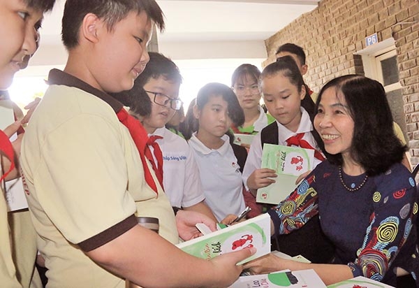  Nhà văn Hoàng Ngọc Điệp, Phó chủ tịch Hội Văn học nghệ thuật tỉnh ký tặng sách cho học sinh tại buổi sinh hoạt.