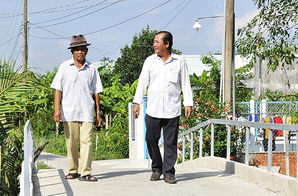 Người dân đi lại trên cây cầu bê tông mới xây dựng ở ấp 2, xã Phước Khánh (huyện Nhơn Trạch)