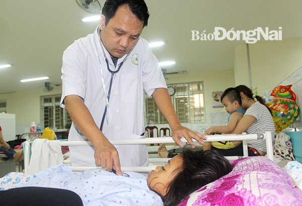 Bác sĩ Nguyễn Thanh Quyền, Trưởng khoa Bệnh nhiệt đới Bệnh viện nhi đồng Đồng Nai thăm khám cho bệnh nhân mắc bệnh tay chân miệng