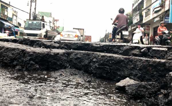 Lớp nhựa đường bị nước mưa cuốn trôi tạo thành hố khá sâu, gây nguy hiểm cho các phương tiện lưu thông qua đây