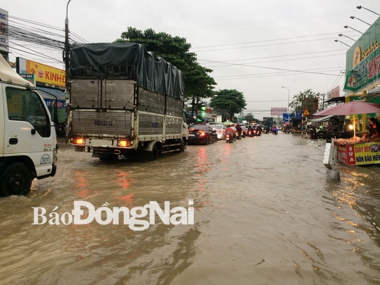 Nước ngập mênh mông trên đường Bùi Văn Hòa (đoạn qua vòng xoay Cổng 11) khiến các phương tiện xếp hàng dài.