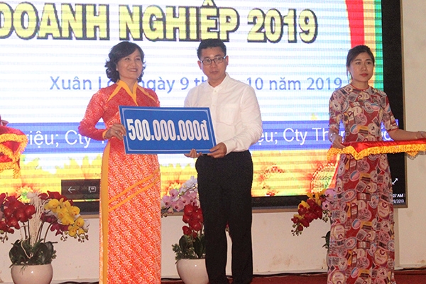 Chủ tịch UBND huyện Xuân Lộc Nguyễn Thị Cát Tiên nhận bảng biểu trưng đóng góp xây dựng Đền thờ liệt sĩ huyện của doanh nghiệp.