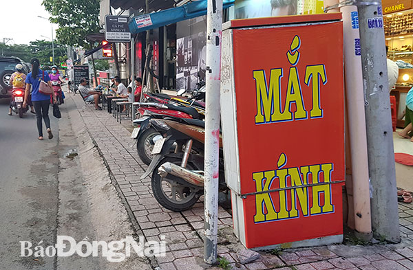 Một tủ viễn thông trên vỉa hè đường Nguyễn Phúc Chu bị quảng cáo của một cửa hàng dán kín một mặt