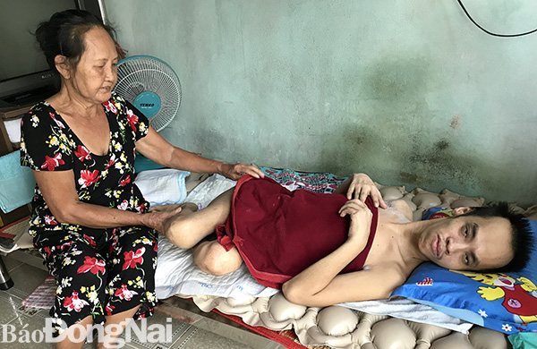 Bà Nguyễn Thị Loan chăm sóc cho con trai Nguyễn Thế An. Ảnh: A.Nhiên