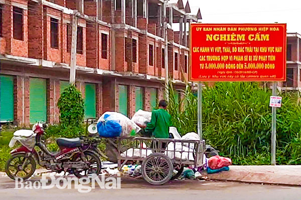 Một người dân lén bỏ rác ngay dưới bảng cấm đổ rác trên đường Đặng Văn Trơn, phường Hiệp Hòa (TP.Biên Hòa). Ảnh: Minh Thành