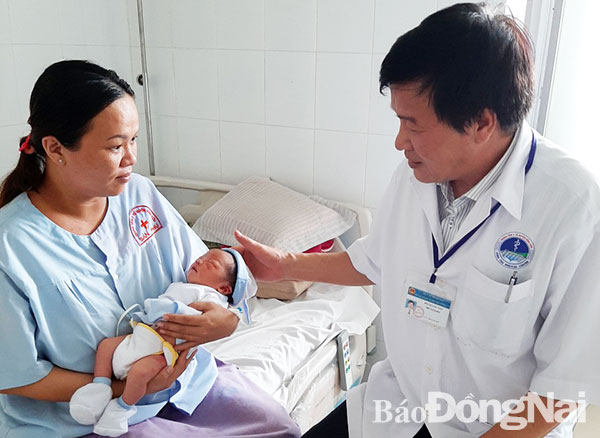 Bác sĩ Bùi Quang Tân thăm khám cho mẹ con sản phụ sau ca mổ