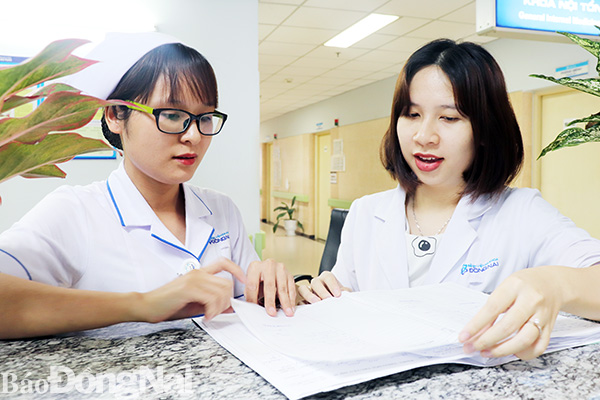 Bác sĩ Nguyễn Dương Thiên Thanh (phải) trao đổi công việc với đồng nghiệp tại Khoa Nội tim mạch Bệnh viện đa khoa Đồng Nai