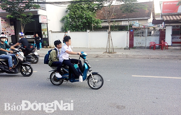Nhiều học sinh ở TP.Biên Hòa đi xe đạp điện lưu thông trên đường nhưng không đội mũ bảo hiểm. Ảnh: A. Nhiên